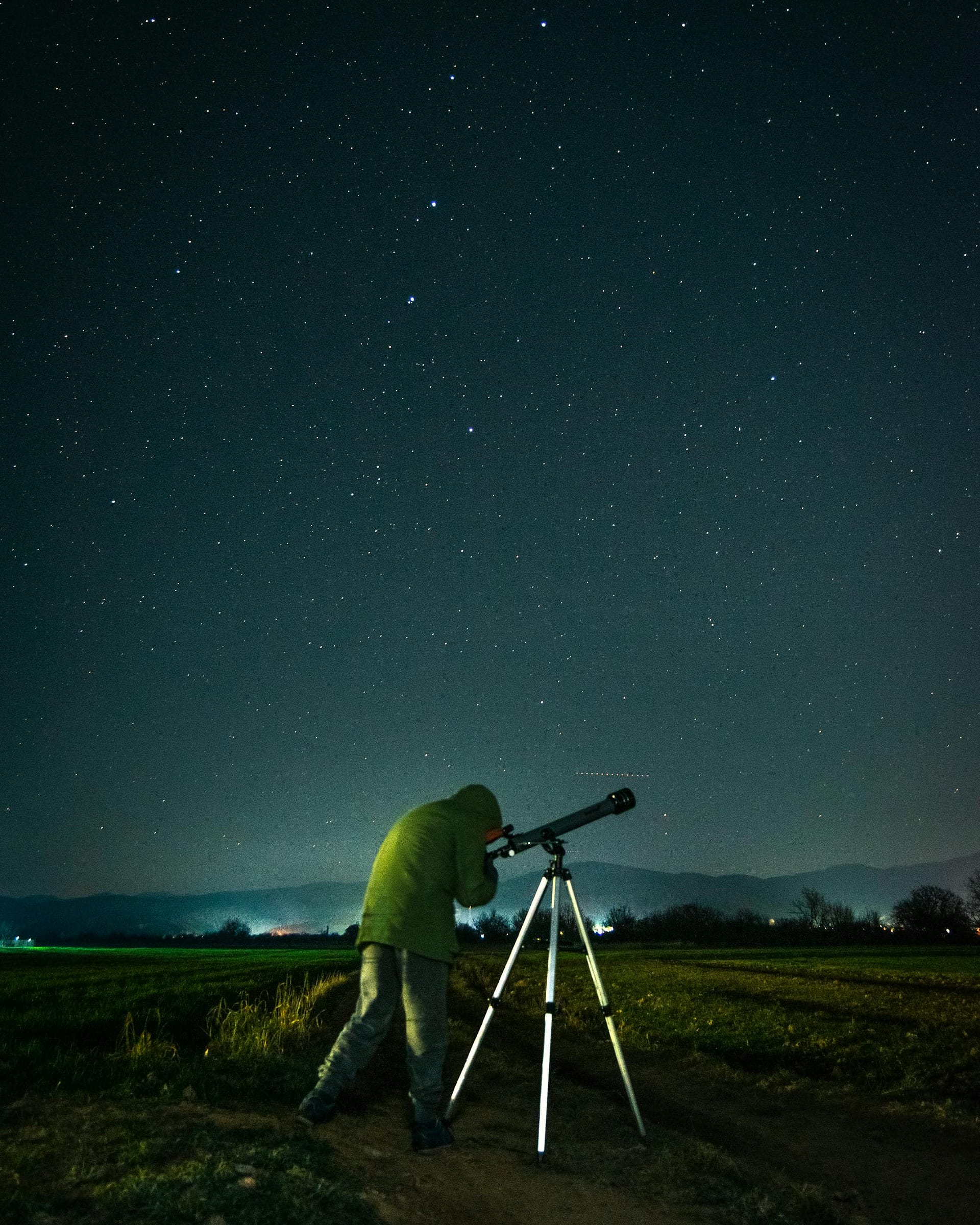 Person stargazing with a telescope under the starry sky in Ohrid, North Macedonia.